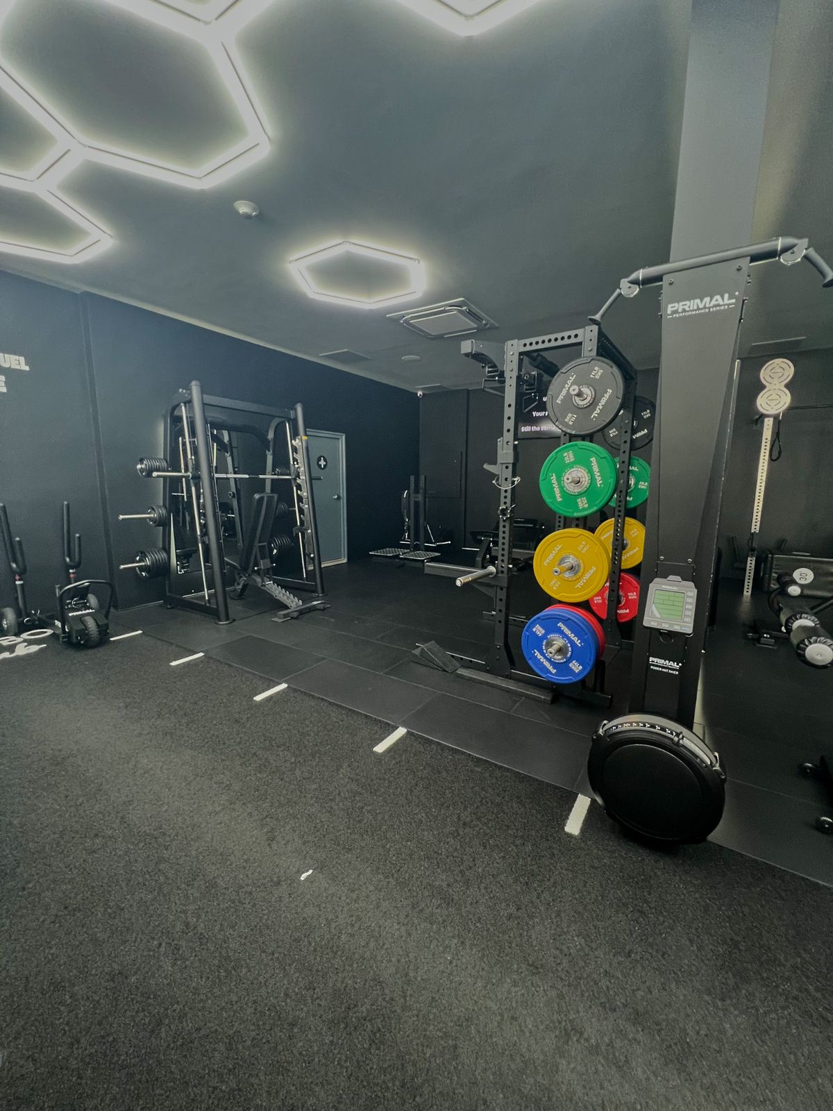 A Smith machine and colour bumper plates on a Primal rack